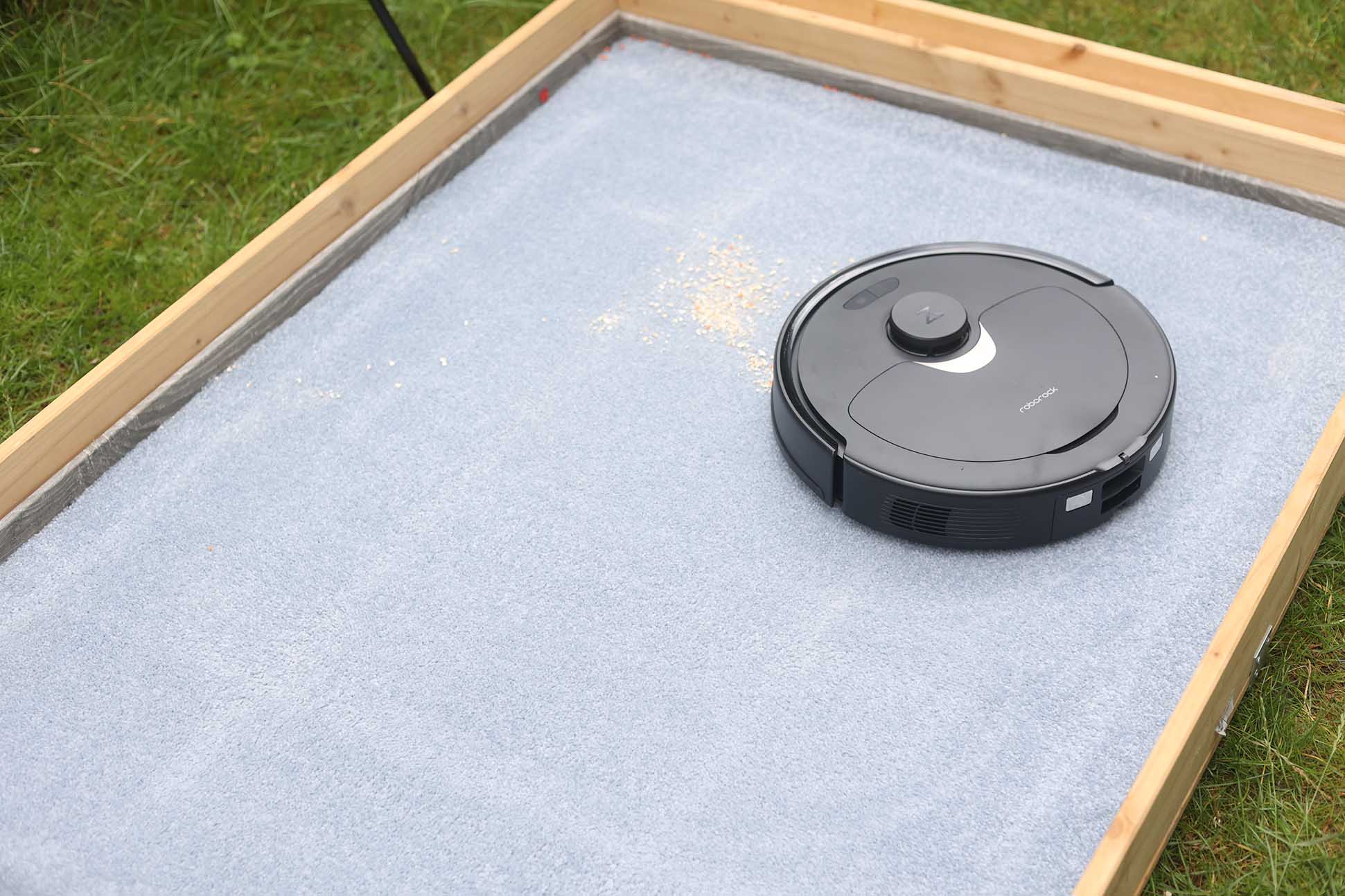 Roborock Q Revo убирает овсяные хлопья на ковре.